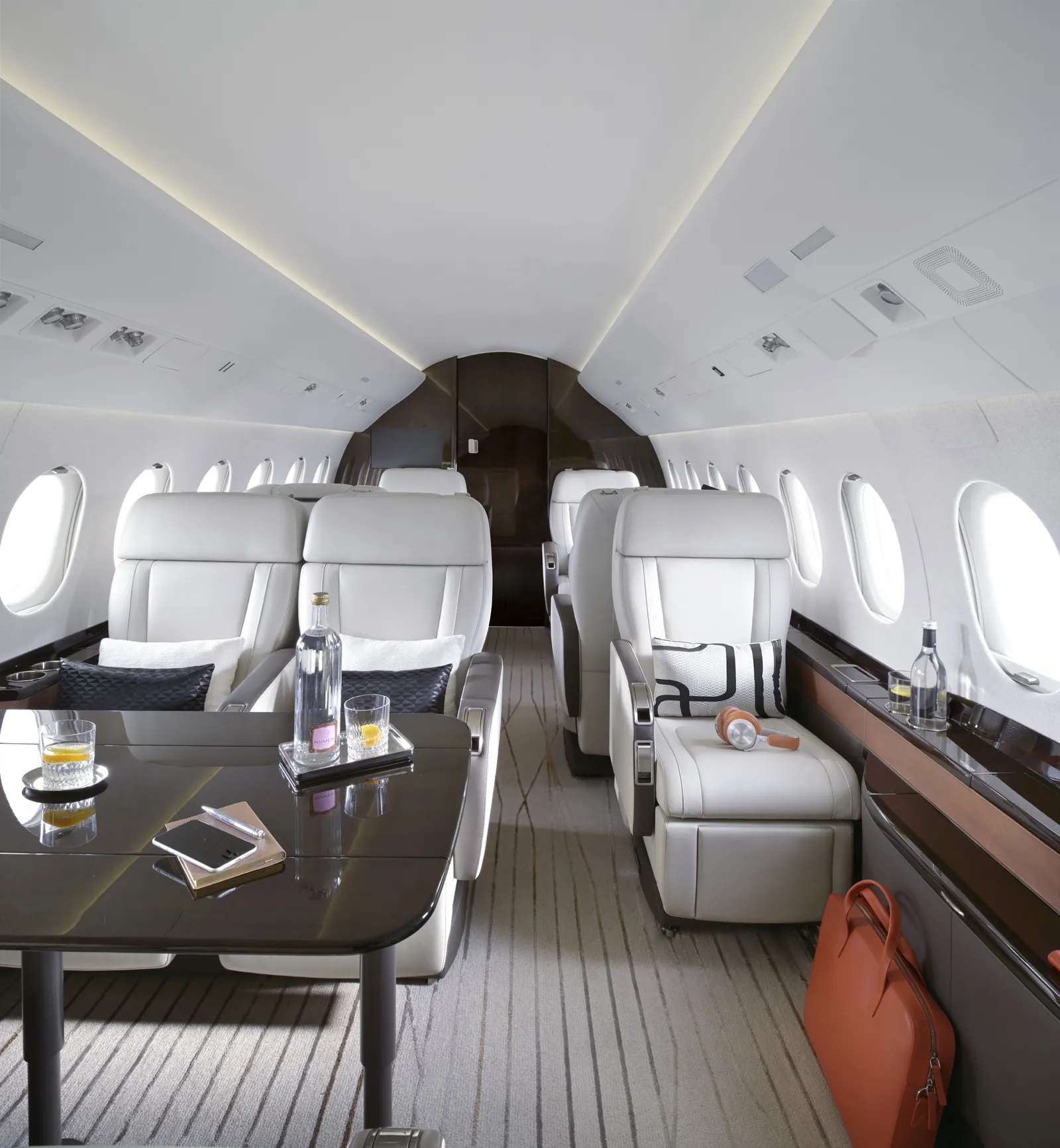 Kabine der Dassault Falcon 2000LXS mit weißen Ledersesseln um einen Tisch