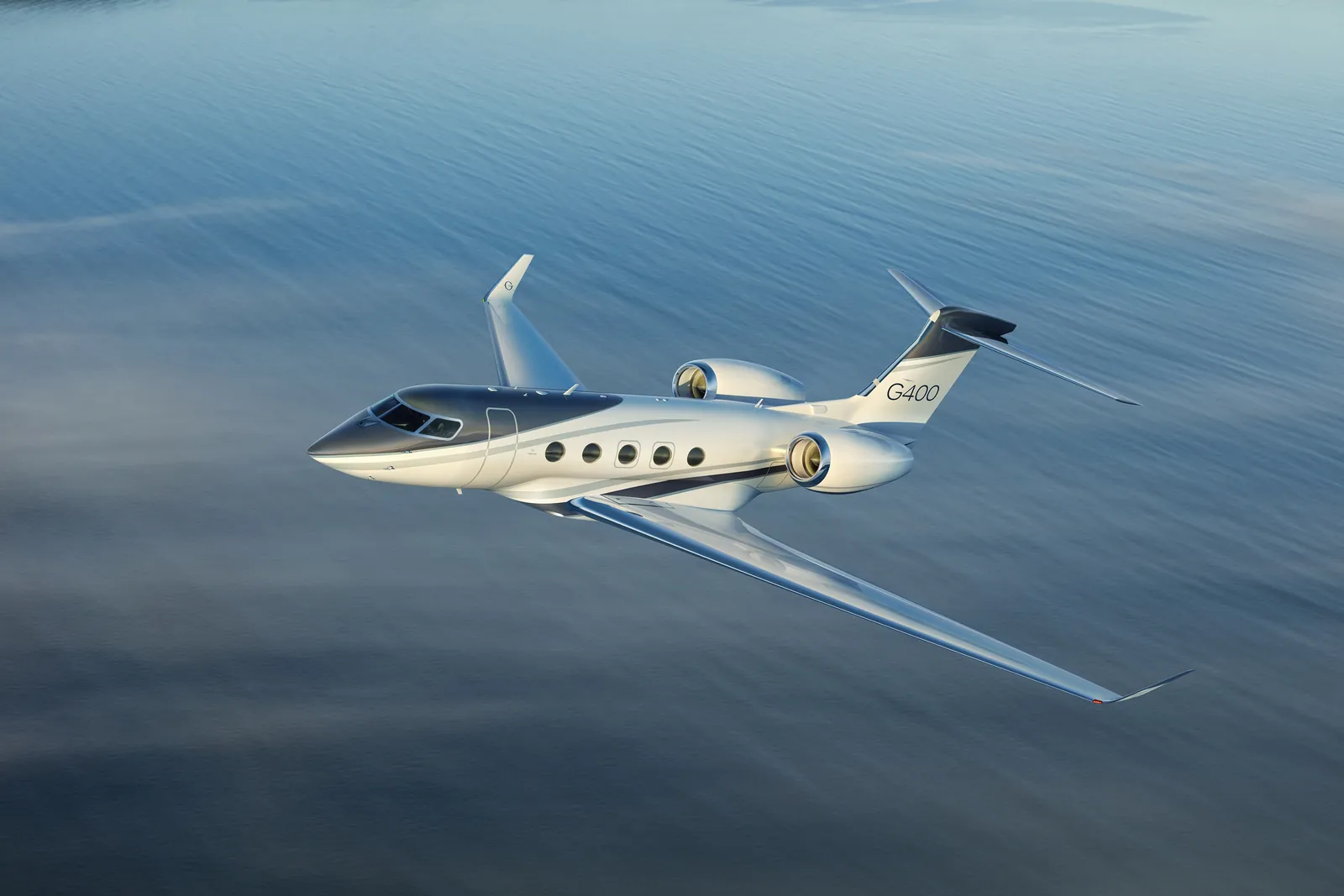 Gulfstream G400 im Flug über ruhigem, blauem Wasser