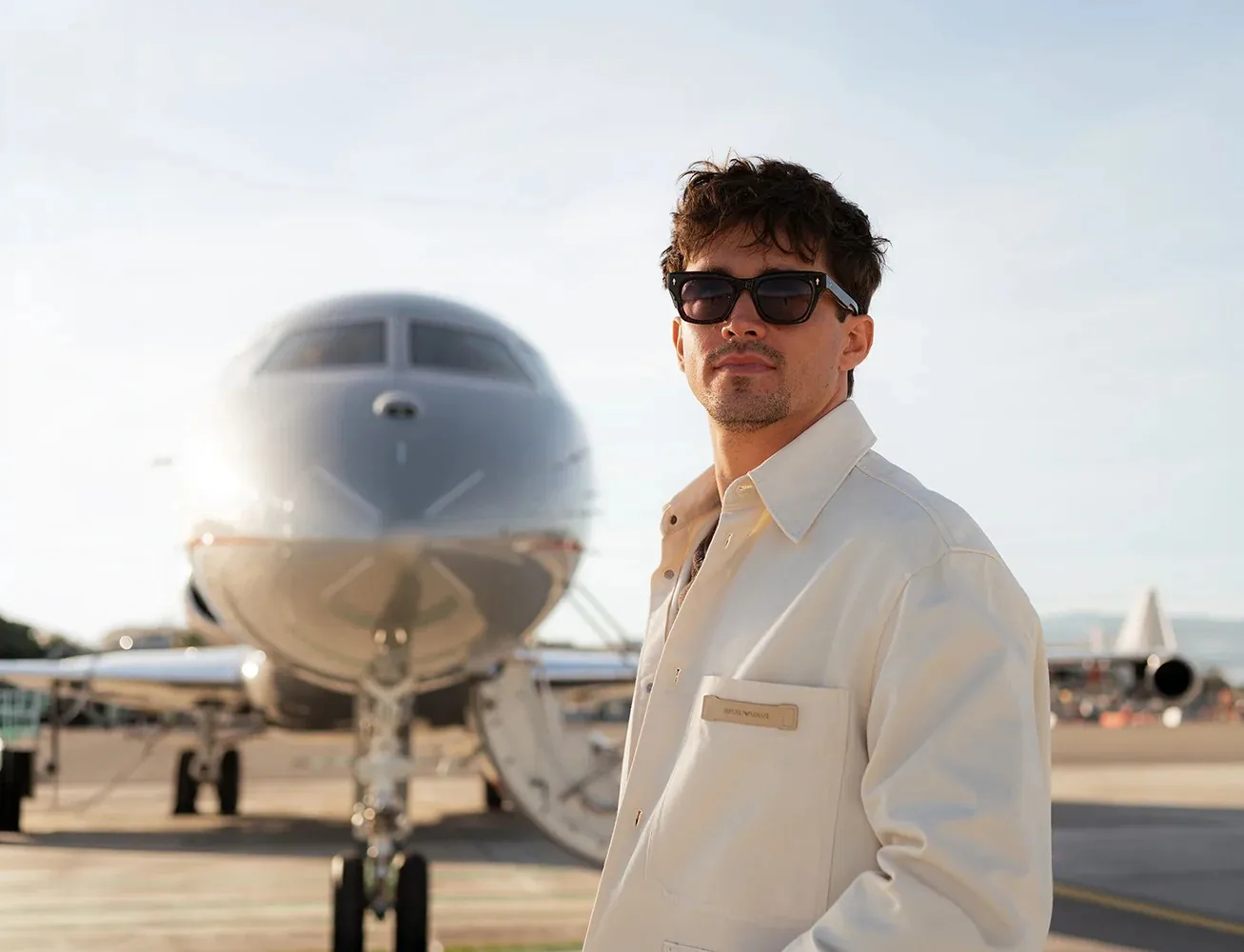Charles Leclerc, Markenbotschafter von VistaJet, auf dem Vorfeld vor einem silbernen VistaJet-Businessjet